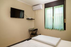 a room with two beds and a tv and a window at Apartments Villa Sabina in Pula
