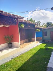 a red house with a yard in front of it at Pousada Villa Maria Corumbau in Corumbau