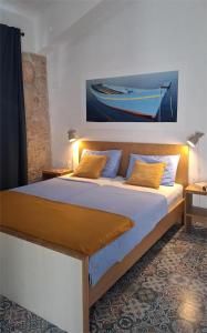 una camera da letto con un letto e un dipinto di una barca sul muro di Agave apartments a Stara Baška