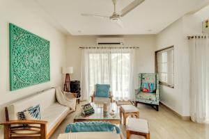 Una sala de estar con un sofá y sillas y una mesa. en Luxury 3bhk penthouse Candolim beach 10 mins, en Goa