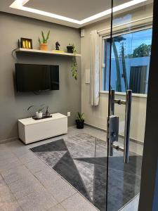 a living room with a flat screen tv on a wall at Casa aconchegante em Aracaju na Aruana in Aracaju