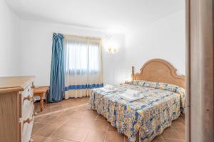 a bedroom with a bed and a table and a window at -Vista Mare- Casa con piscina e spiaggia a 300 MT in Liscia di Vacca