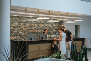a group of people standing at a counter in an office at Almyra Resort in Koutsounari