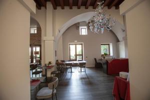 a dining room with tables and chairs and a chandelier at Hotel Cristallo in Conegliano