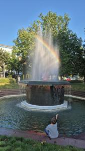 ブライトン＆ホーブにあるBeachfront, 2-bedroom, Sleeps 5, long staysの虹のかかった噴水の前に座っている子供