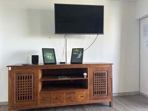 a wooden entertainment center with a flat screen tv on top at Zèl O Van in Petite Île