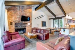 a living room with leather furniture and a brick wall at Happy Daze Big Space Near Village Hot Tub 38L-194 in Blue Mountains