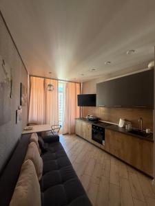 a living room with a couch and a kitchen at Arkadia Terrace in Odesa
