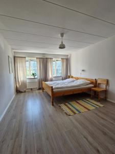 a bedroom with a bed and two windows at Nordbakks holiday apartments in Frostviken, Gäddede in Gäddede