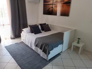 un letto con cuscini neri sopra in una camera da letto di CasaYudi Monolocale con piscina ad Aprilia Marittima Altre 12 foto