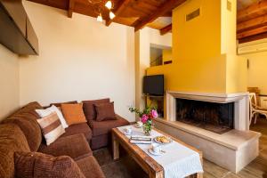 a living room with a couch and a fireplace at Villa Eftichia in Stalos