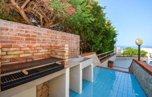 eine Backsteinmauer mit einer Bank auf einer Terrasse in der Unterkunft Nice Home In Marina Di Ragusa in Marina di Ragusa