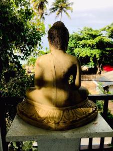 une statue d'une femme assise sur un banc dans l'établissement Black Lantern, à Matara