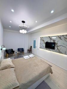 a bedroom with a bed and a tv on a wall at The Frunze One in Bishkek