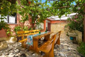 a wooden table and chairs on a patio at Apartments Villa Sabina in Pula