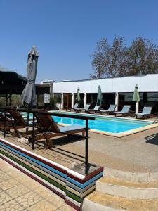 - une piscine avec des chaises et des parasols à côté d'un bâtiment dans l'établissement Omega Mamaia Nord, à Mamaia Nord – Năvodari 10 autres photos