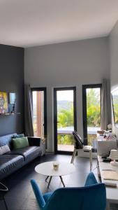 a living room with a couch and a table at Latitude vue unique in Les Trois-Îlets