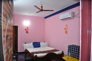 a room with a bed and a ceiling fan at Raja Home stay in Tiruvannāmalai