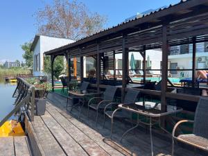 un restaurant avec des tables et des chaises sur un quai dans l'établissement Omega Mamaia Nord, à Mamaia Nord – Năvodari