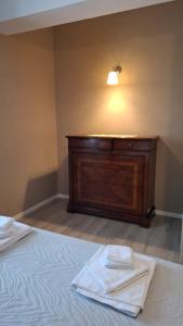 a bedroom with a bed with a dresser and two towels at Casa Vacanze Stefania in Maccarese