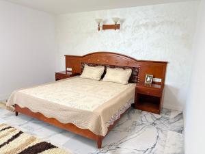 a bedroom with a large bed with two night stands at IsTh Wave House in Vadu