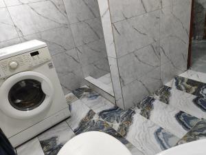 a bathroom with a toilet and a washing machine at Guest house Gosling in Almaty