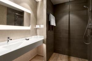 een badkamer met een wastafel en een douche bij AC Hotel by Marriott Wroclaw in Wrocław +64 foto's