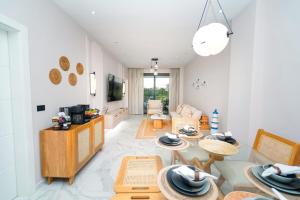 - un salon avec des tables, des chaises et un canapé dans l'établissement Cana Rock Star D209 Jaccuzi Pool Golf and Private Beach, à Punta Cana