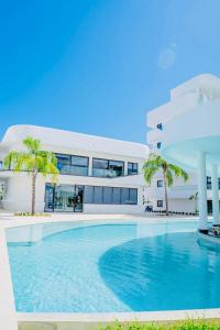 - un grand bâtiment blanc avec une piscine en face dans l'établissement Cana Rock Star D209 Jaccuzi Pool Golf and Private Beach, à Punta Cana