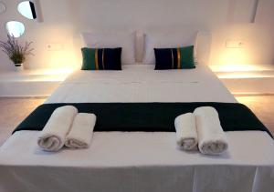 a bedroom with a bed with rolled towels on it at AGAPI apartments in Kithnos