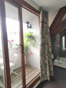 a sliding glass door with a curtain on a porch at B&B La Ducale in Ghent