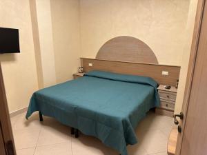 a small bedroom with a bed with a blue blanket at Il Rifugio dell'Orso in Castel di Sangro