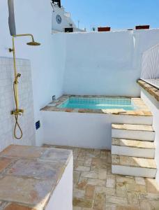 a bathroom with a tub and stairs in a room at Plaza España 5 Casa con encanto, terraza y vistas in Vejer de la Frontera