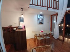 a kitchen and dining area with a table and a dining room at Warm kabin dieng in Diyeng