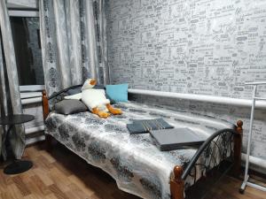 a bedroom with a bed with a teddy bear on it at Guest house Gosling in Almaty