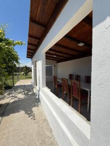 a porch with chairs and a table on the side of a house at IsTh Wave House in Vadu