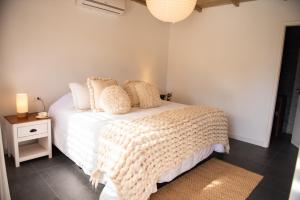 a bedroom with a white bed and a nightstand with a lamp at La Posadita in José Ignacio +24 photos