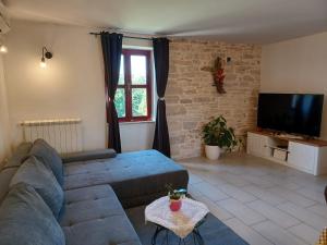 a living room with a couch and a tv at Casa Felice in Bale