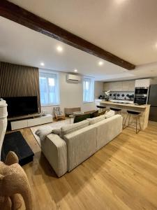 un soggiorno con un grande divano e una cucina di Le Parifou Family home in Riom Puy de Dome a Riom