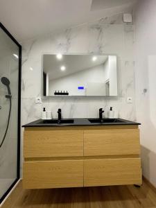 un bagno con lavandino e specchio di Le Parifou Family home in Riom Puy de Dome a Riom