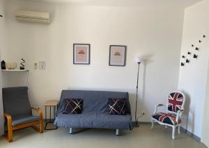 a living room with a blue couch and two chairs at Oleander House apartments in Torri del Benaco