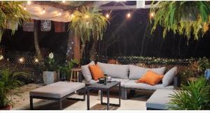 un divano bianco con cuscini arancioni su un patio di Casa Bohemia a Palma Sola