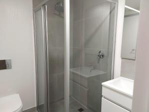 a bathroom with a shower with a toilet and a sink at 311 The Meadows in George