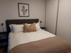 a bed with white sheets and pillows in a bedroom at 311 The Meadows in George