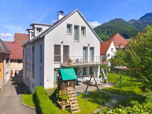 a white house with a playground in the yard at Gästehaus Eisenerz in Eisenerz