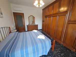 a bedroom with a blue bed and wooden cabinets at Appartamento Miramare in Vado Ligure