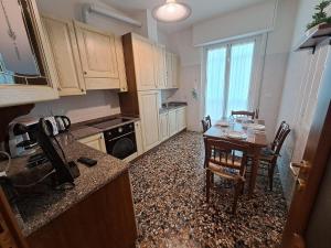 a kitchen with a table and a dining room at Appartamento Miramare in Vado Ligure