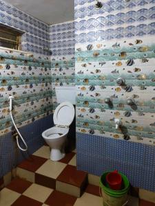 un bagno con un water e una carta da parati con un pinguino di Subharaj palace and restaurant 