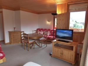 莱斯奥琉斯Charmant 2 pièces avec terrasse, 4 pers, Méribel, animaux admis, WIFI, 3* - FR-1-411-379的配有电视和桌椅的客厅