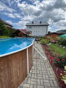 a swimming pool in a yard with a wooden fence at Penzión u Veroniky in Ždiar